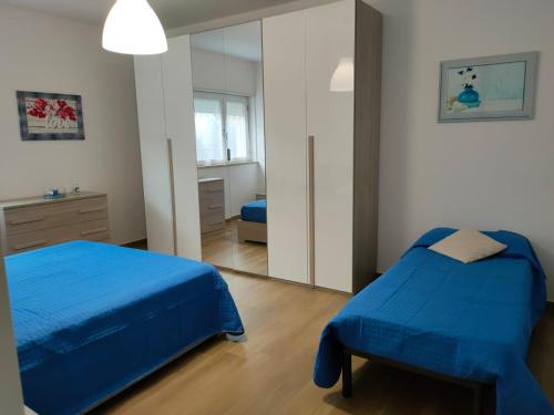 1 Schlafzimmer mit 2 Betten und einem Spiegel in der Unterkunft Villino Maria Pia, appartamento in villino in centro storico L'Aquila in LʼAquila