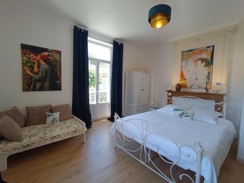 um quarto com uma cama, um sofá e uma janela em Maison sur le Lot em Saint-Vincent-Rive-dʼOlt