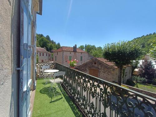 a balcony with a table and chairs on the grass at Maison sur le Lot in Saint-Vincent-Rive-dʼOlt