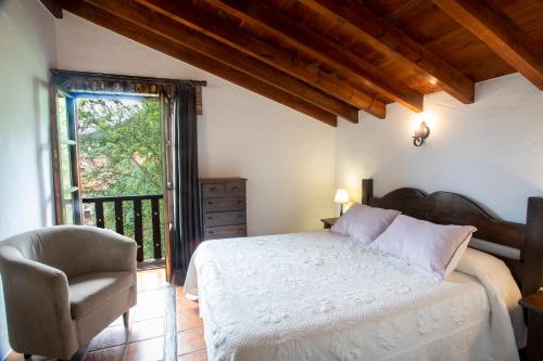 1 dormitorio con 1 cama, 1 silla y 1 ventana en Hotel Rural Valleoscuru en Tresgrandas