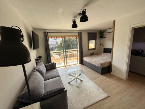salon z kanapą i łóżkiem w obiekcie Cozy studio apartment in Cannes - AC-Self check-in w Cannes