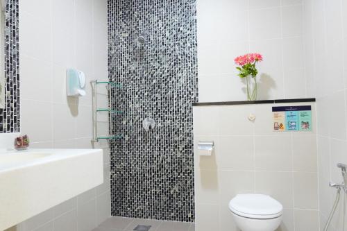a white bathroom with a toilet and a sink at Zecon Hotel in Kuala Lumpur