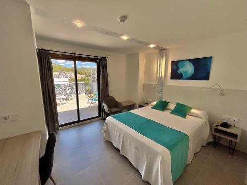 サンアントニオにあるHotel Brisa - Adults onlyのベッドと大きな窓が備わるホテルルームです。
