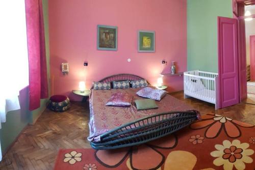 - une chambre avec un lit et un mur rose dans l'établissement Josephine Central Villa & Garden, à Cluj-Napoca