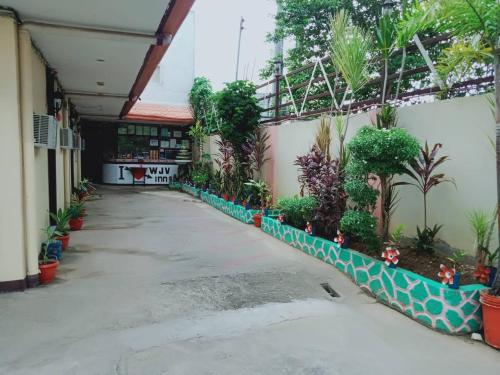 une cour d'un bâtiment avec des plantes sur le côté dans l'établissement WJV INN Bankal, à Bankal