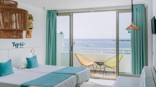a bedroom with a bed and a view of the ocean at Typic Marina Playa - Adults Only in San Antonio Bay