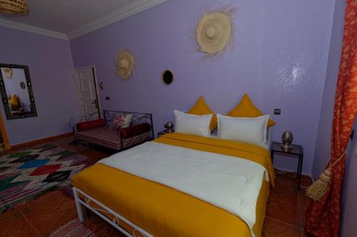 a bedroom with a large bed with yellow and white pillows at Riad Parfums de OUARZAZATE in Ouarzazate