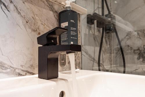 a black water faucet on a white sink at Hyde Park Green in London