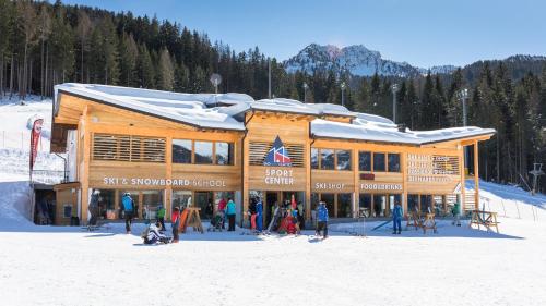 un gruppo di persone che si trovano di fronte a un rifugio da sci di Appartamenti Gosetti - CIPAT 022114-AT-060137 a Mezzana