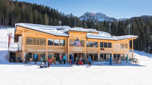 un groupe de personnes se tenant devant un pavillon de ski dans l'établissement Appartamenti Gosetti - CIPAT 022114-AT-060137, à Mezzana