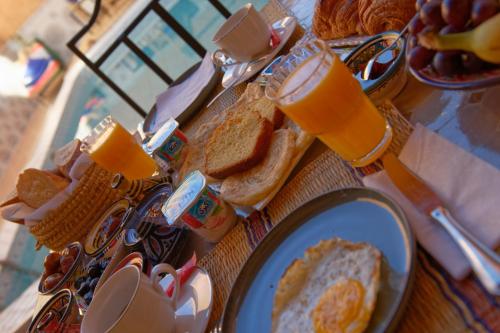 a table with a plate of toast and orange juice at Riad Parfums de OUARZAZATE in Ouarzazate