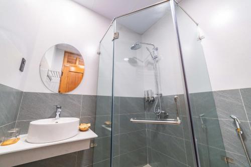 a bathroom with a sink and a glass shower at Quốc Khánh Condotel in Da Lat
