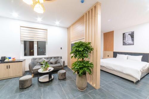 a hotel room with a bed and a couch at Quốc Khánh Condotel in Da Lat