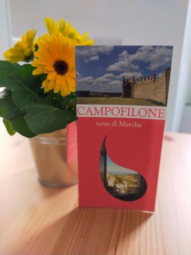 a book sitting on a table next to a flower at BnB La Casina dei Nonni in Campofilone