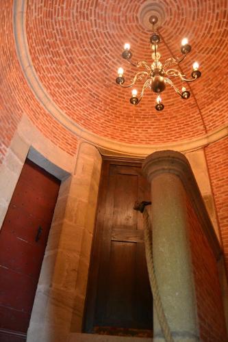 a chandelier hanging from a ceiling in a building at Château de Peufeilhoux in Vallon-en-Sully