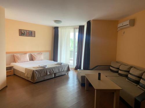 a hotel room with a bed and a couch at Aparthotel Hotel Prestige City II in Primorsko
