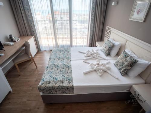 a bedroom with a large bed with bows on it at Cristiani Hotel Sozopol in Sozopol