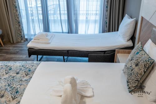 a hotel room with two beds and a couch at Cristiani Hotel Sozopol in Sozopol