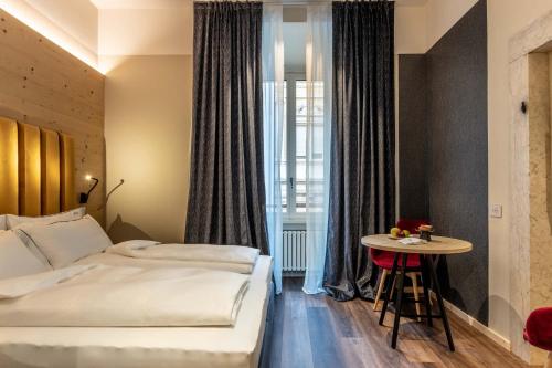 a hotel room with a bed and a table at Calepina Alpine Suite in Trento