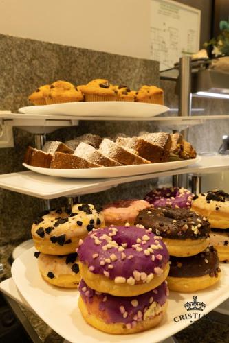 a display of different types of donuts and pastries on shelves at Cristiani Hotel Sozopol in Sozopol