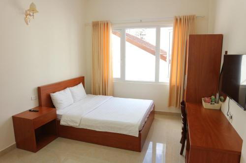 um quarto com uma cama, uma televisão e uma janela em Mây Đà Lạt Home em Da Lat