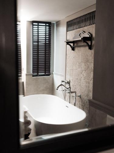 a bathroom with a white tub and a sink at Burirattana Hotel-An Adults Only Hotel in Chiang Mai