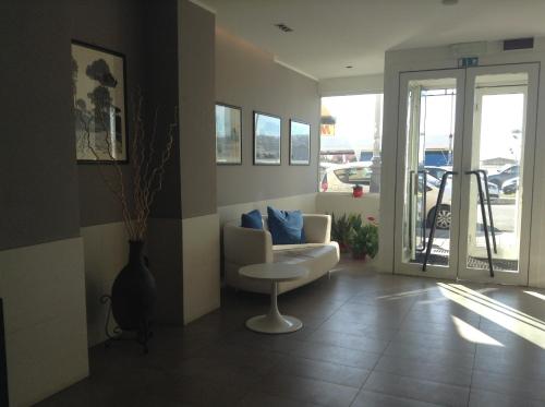 a living room with a white couch and a table at Hotel La Scaletta in Lido di Ostia