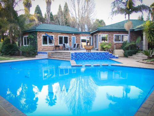 a swimming pool in front of a house at Sunrise Serenity Guest House in Lydenburg