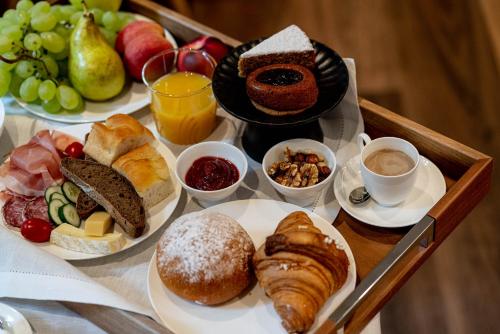 a tray filled with different types of breakfast foods at Calepina Alpine Suite in Trento