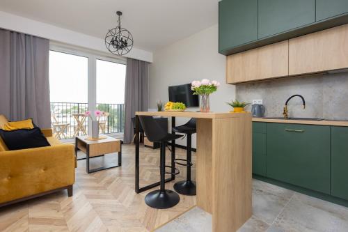 uma cozinha com armários verdes e uma mesa com cadeiras em Home Factory Estate Praga Kotsisa by Renters em Varsóvia
