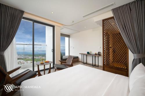 トゥイホアにあるMandala Hotel & Spa Phú Yênのベッドルーム1室(ベッド1台、大きな窓付)