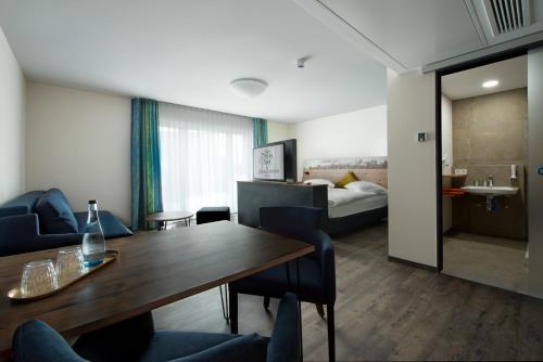 um quarto de hotel com uma mesa e cadeiras e uma cama em Hotel Zum Grünen Baum em Pfahlheim
