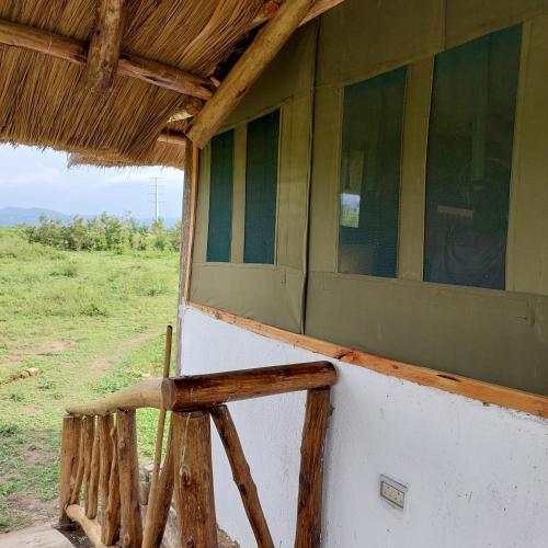 a side view of a building with a porch at Songbird Safari Lodge & Campsite in Katunguru