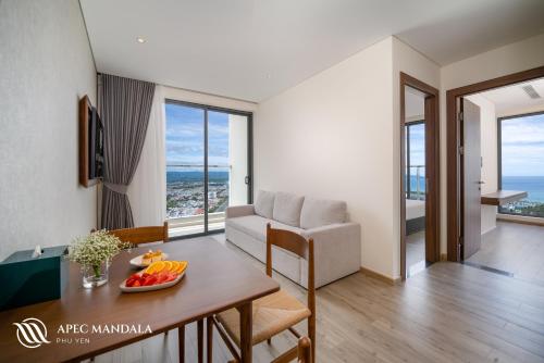 a living room with a table and a couch at Mandala Hotel & Spa Phú Yên - 24hours Stay in Tuy Hoa