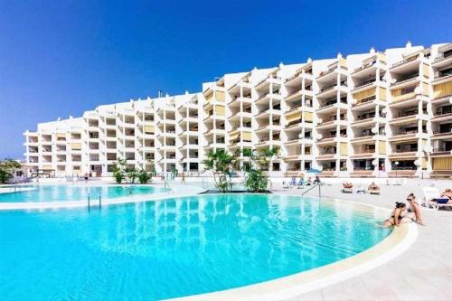 un gran hotel con una gran piscina frente a él en Blue Cristianos by W Tenerife, en Los Cristianos