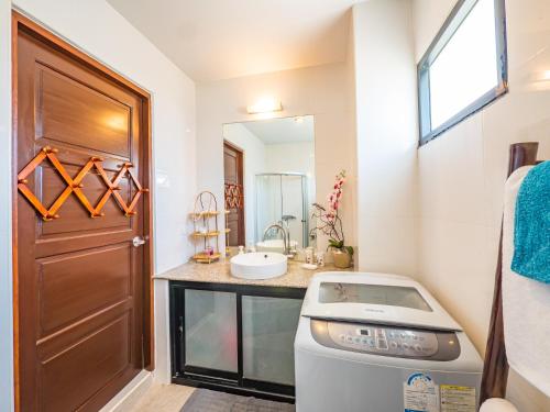 uma casa de banho com um lavatório e uma máquina de lavar roupa em Condo AVANTA Deluxe A301 em Mae Nam