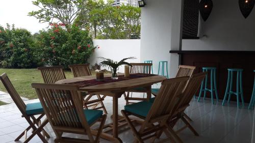 einen Holztisch und Stühle auf einer Terrasse in der Unterkunft Beach Front Bungalow Tanjung Bungah in George Town