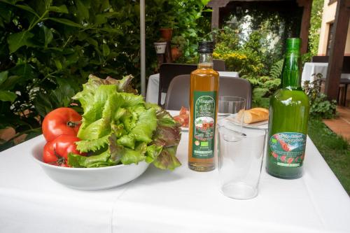 a table with a bowl of lettuce and two bottles of alcohol at Hotel Rural Valleoscuru in Tresgrandas