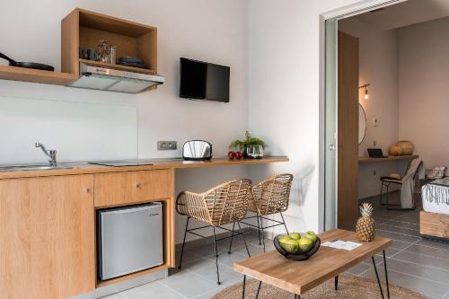 a kitchen and living room with a table and chairs at Villa Di Mare Seaside Suites in Ixia