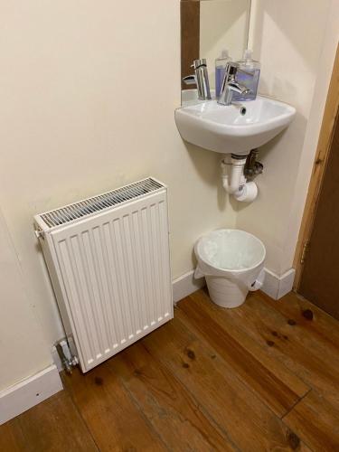 a bathroom with a white radiator and a sink at EdinB&B in Edinburgh