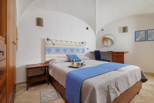 een slaapkamer met een groot bed en een blauwe deken bij Villetta Azzurro - SHERDENIA Luxury Apartments in Marinella