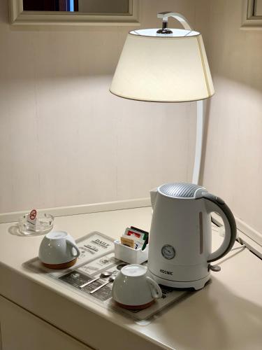 a coffee maker sitting on a counter next to a lamp at Hotel La Pace in San Mauro Torinese