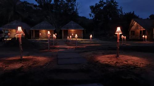 a group of lights in front of some huts at night at Banana Tree Home Stay in Hampi