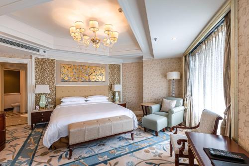 a bedroom with a bed and a desk and a chair at Shangri-La Wuhan,Close to The Mixc with three subway lines in Wuhan