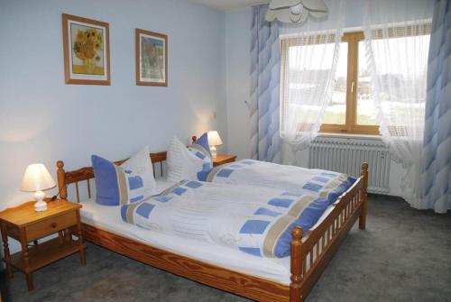 um quarto com uma cama grande com lençóis azuis e brancos em Gästehaus Am Ludwigsberg em Bad Kötzting