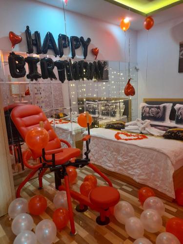 a room with a bed and a red chair and balloons at Tina 2 Hotel in Cái Răng