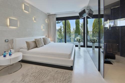 a bedroom with a white bed and a large window at Charo - San Jose in Sant Josep de sa Talaia