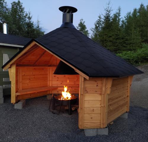 a large wooden dog house with a fire in it at Villa Granbacka Raasepori Karjaa Finland in Karjaa