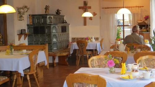 a man sitting at a table in a restaurant at Gästehaus Am Ludwigsberg in Bad Koetzting
