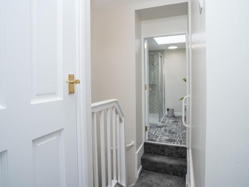 a hallway with a stairway with a door leading into a room at The Views Townhouse in Newcastle